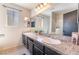 Bathroom featuring a dual-sink vanity with granite countertops, mirrors, and updated fixtures at 4932 Goldeneye Way, North Las Vegas, NV 89031