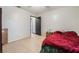 Neutral bedroom with tile floor, large bed with a red comforter, and a small bedside table at 4932 Goldeneye Way, North Las Vegas, NV 89031