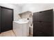 Functional laundry room with a washer, dryer, overhead shelving, and a storage cabinet for household convenience at 4932 Goldeneye Way, North Las Vegas, NV 89031