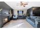 Cozy living room with a brick fireplace, tile floor, and ceiling fan at 4932 Goldeneye Way, North Las Vegas, NV 89031