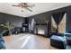 Living room features dark paint, a black brick fireplace, and a ceiling fan at 4932 Goldeneye Way, North Las Vegas, NV 89031