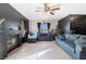 Cozy living room with a brick fireplace, tile floor, and ceiling fan at 4932 Goldeneye Way, North Las Vegas, NV 89031