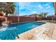 Sparkling outdoor pool with a rock waterfall and slide feature, surrounded by a stamped concrete patio at 4932 Goldeneye Way, North Las Vegas, NV 89031