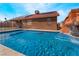 Beautiful pool view with a built-in waterfall, solar panels, and a secure fence at 4932 Goldeneye Way, North Las Vegas, NV 89031