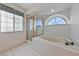 Bright bathroom featuring a soaking tub, glass shower, and half-moon window at 544 Cervantes Dr, Henderson, NV 89014