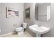 Classic half bath featuring a pedestal sink, toilet, neutral walls and decorative art at 5968 Saint Lazare St, Las Vegas, NV 89130