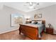 Bedroom with cozy carpet, ceiling fan, wood furnishings, and a window with plantation shutters at 5968 Saint Lazare St, Las Vegas, NV 89130