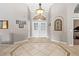 Inviting foyer with tile flooring, neutral paint, an arched entryway, and a decorative light fixture at 5968 Saint Lazare St, Las Vegas, NV 89130