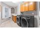 Convenient laundry room with modern washer and dryer, storage cabinets, and window at 5968 Saint Lazare St, Las Vegas, NV 89130