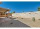 View of a backyard with minimal desert landscaping, a block wall, and covered patio at 6412 Yarmouth Dr, Las Vegas, NV 89108