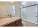 Bathroom featuring a vanity, large mirror, toilet, and a glass-doored shower-tub combo at 6412 Yarmouth Dr, Las Vegas, NV 89108