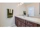 Bathroom featuring double sinks, a large mirror, dark wood cabinets and plenty of counter space at 6412 Yarmouth Dr, Las Vegas, NV 89108