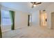 Bedroom with neutral carpeting, a ceiling fan, and windows with green curtains at 6412 Yarmouth Dr, Las Vegas, NV 89108