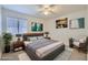 Staged bedroom featuring a bed, two side tables, and contemporary decorations with light from a window at 6412 Yarmouth Dr, Las Vegas, NV 89108