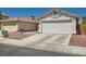 View of home's facade, featuring two-car garage, stucco exterior, low-maintenance landscaping at 6412 Yarmouth Dr, Las Vegas, NV 89108