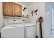 Utility room features a washer, dryer, utility sink, and upper cabinets for storage at 6412 Yarmouth Dr, Las Vegas, NV 89108