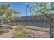 A tennis court is surrounded by trees and vibrant flowers, providing an inviting recreational space at 6412 Yarmouth Dr, Las Vegas, NV 89108