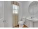 This powder bathroom features a round mirror, a white sink, and neutral paint at 7083 Mackenzie Bay Ave, Las Vegas, NV 89179