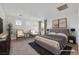 Staged bedroom with plush bedding, accent seating, and lots of natural light at 7083 Mackenzie Bay Ave, Las Vegas, NV 89179