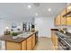 This staged kitchen has stainless appliances, a large island, and light wood cabinets at 7083 Mackenzie Bay Ave, Las Vegas, NV 89179