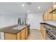 This kitchen has stainless appliances, a large island, and light wood cabinets at 7083 Mackenzie Bay Ave, Las Vegas, NV 89179