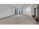 Expansive living room featuring neutral carpeting, built-in media center, and lots of natural light at 7083 Mackenzie Bay Ave, Las Vegas, NV 89179