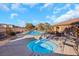 A community pool with a hot tub features ample seating and landscaping in a resort-style setting at 7083 Mackenzie Bay Ave, Las Vegas, NV 89179