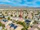 An aerial view showcasing a community with desert landscaping, mountains, and multiple solar panels at 7757 Coast Jay St, North Las Vegas, NV 89084