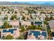 Aerial view of a neighborhood featuring homes with solar panels and desert landscaping in a vibrant community at 7757 Coast Jay St, North Las Vegas, NV 89084