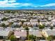 Expansive aerial view showcasing a thriving residential community with neatly arranged homes under a clear blue sky, and mountain views at 7757 Coast Jay St, North Las Vegas, NV 89084