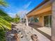 Landscaped backyard featuring covered patio, decorative rock, manicured trees and bushes at 7757 Coast Jay St, North Las Vegas, NV 89084