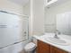 Bright bathroom with tub-shower combo, white tile surround, single sink vanity, and white toilet at 7757 Coast Jay St, North Las Vegas, NV 89084