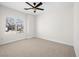 Well-lit bedroom with neutral carpet, a ceiling fan, and a large window offering natural light at 7757 Coast Jay St, North Las Vegas, NV 89084