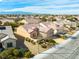 Tan single-story home featuring a tile roof, two-car garage, and low maintenance desert landscaping at 7757 Coast Jay St, North Las Vegas, NV 89084