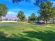 View of the lush green Aliante Golf Course, with mature trees and mountain views at 7757 Coast Jay St, North Las Vegas, NV 89084