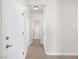 A hallway with white doors and tile floor leads to a full bathroom with shower and tub combination at 7757 Coast Jay St, North Las Vegas, NV 89084