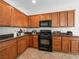 Kitchen cabinets with black appliances and dark countertops in a brightly lit kitchen, virtually staged at 7757 Coast Jay St, North Las Vegas, NV 89084