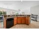 Kitchen sink and dishwasher with wood cabinets and dark countertops, in a bright space, virtually staged at 7757 Coast Jay St, North Las Vegas, NV 89084