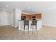 Kitchen island with wood cabinets and dark countertops with bar stool seating, virtually staged at 7757 Coast Jay St, North Las Vegas, NV 89084