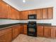 Kitchen with wood cabinets, dark countertops and black appliances at 7757 Coast Jay St, North Las Vegas, NV 89084