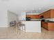 Kitchen featuring wood cabinets and dark countertops with bar stool seating, virtually staged at 7757 Coast Jay St, North Las Vegas, NV 89084