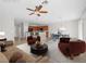 Staged living room with kitchen view, featuring tile floors, and a ceiling fan at 7757 Coast Jay St, North Las Vegas, NV 89084