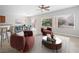 Virtually staged open concept living room and dining area with large windows and neutral color palette at 7757 Coast Jay St, North Las Vegas, NV 89084