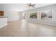 Living room with neutral walls and tiled floors, adjacent to a dining area, filled with natural light at 7757 Coast Jay St, North Las Vegas, NV 89084