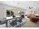 Virtually staged open concept living room and dining area with large windows and neutral color palette at 7757 Coast Jay St, North Las Vegas, NV 89084