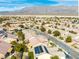 A charming street view with green lawns and homes with desert landscaping, some featuring solar panels at 7757 Coast Jay St, North Las Vegas, NV 89084