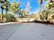 Backyard with a spacious patio and lush landscaping with green trees at 880 Glitter Glen Ct, Las Vegas, NV 89123