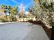 Backyard with a spacious patio and lush landscaping with green trees at 880 Glitter Glen Ct, Las Vegas, NV 89123