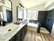 Bathroom features double sinks, neutral-colored cabinetry, tub, and black tiled walk-in shower at 880 Glitter Glen Ct, Las Vegas, NV 89123