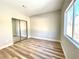 Bright bedroom with a large window, mirrored closet doors and wood-look flooring at 880 Glitter Glen Ct, Las Vegas, NV 89123